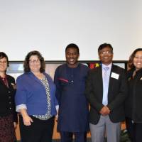 The Global Health Task Force committee standing together with the keynote speaker, smiling